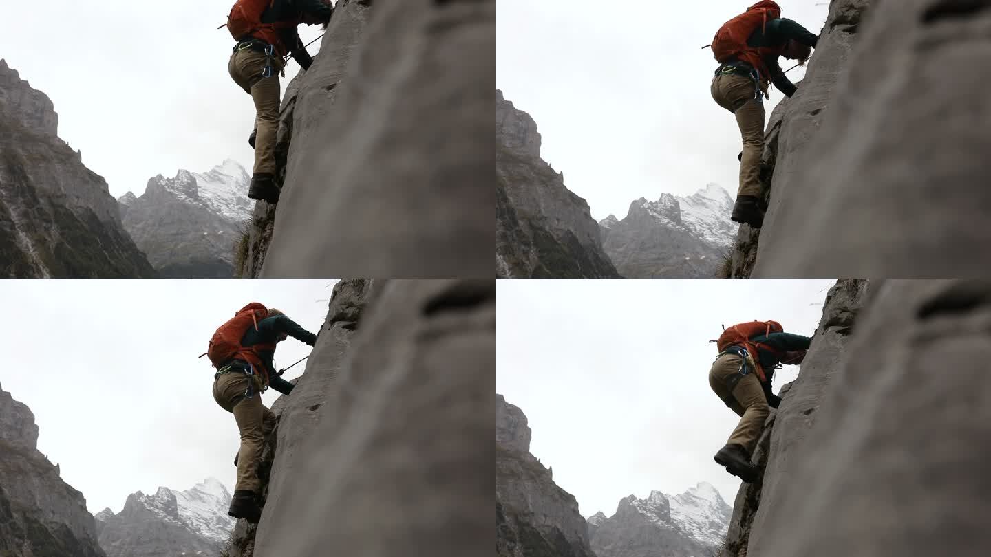 男登山运动员登上陡峭的岩石表面
