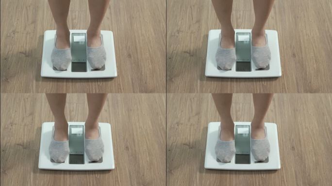 一个女人走进她的房子，她走在磅秤上，用手动体重秤检查她的体重