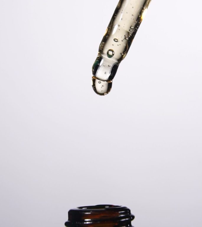 垂直拍摄：缓慢移动的液滴从移液管落入具有中心成分的瓶中