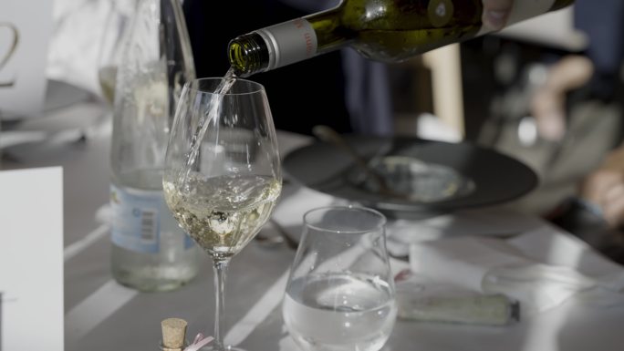 在一张固定的桌子上，葡萄酒倒在玻璃杯里的细节镜头