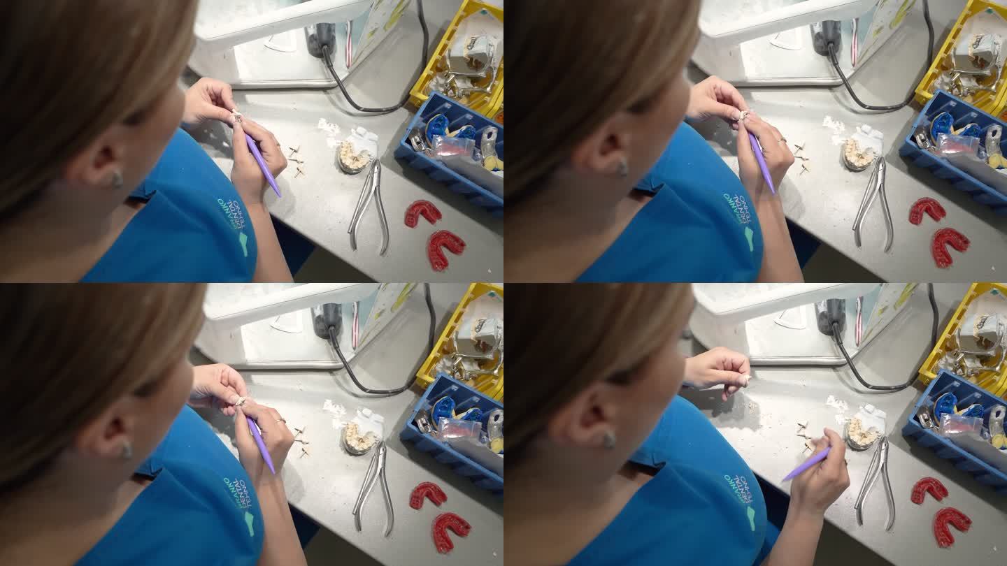 在牙科实验室用钻头打磨假牙的不知名女技师