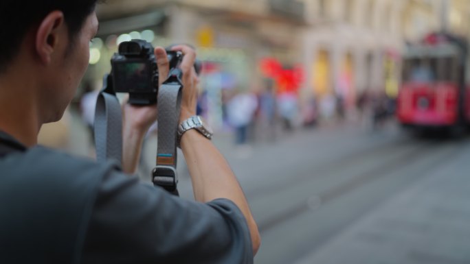 年轻的男性摄影师和摄像师旅游期间在城市拍摄照片和视频