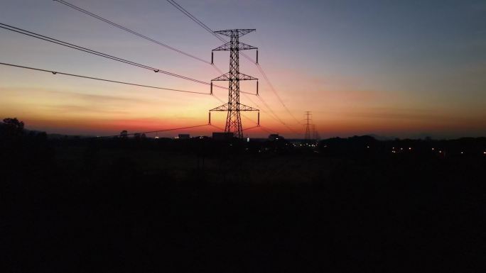 黄昏时分野外高压电线塔的鸟瞰车