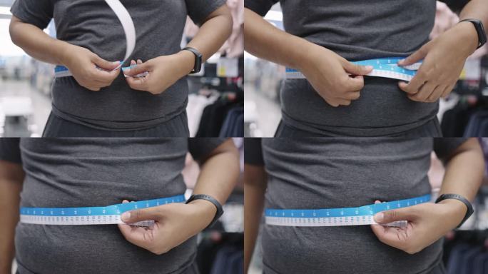 超重男子在购物中心用测量纸测量自己的大肚子