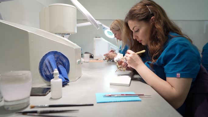 年轻的高加索女技师，在牙科实验室制作假牙