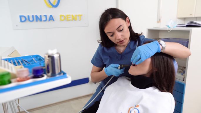 年轻的女牙医为一名女性患者进行牙科手术