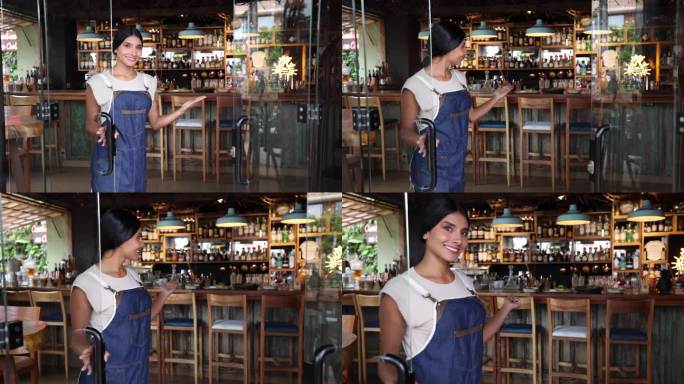 拉丁美洲女服务员打开餐厅大门迎接顾客，面对镜头微笑