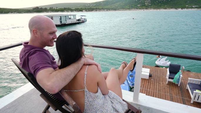 南非开普敦，一对幸福的夫妇坐在船屋甲板上
