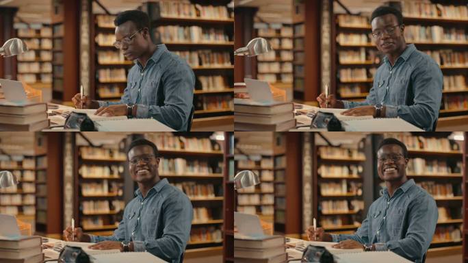 一名男学生在大学图书馆为项目做研究或准备期末考试的肖像。快乐的年轻律师，戴着眼镜，在书桌前阅读课本并