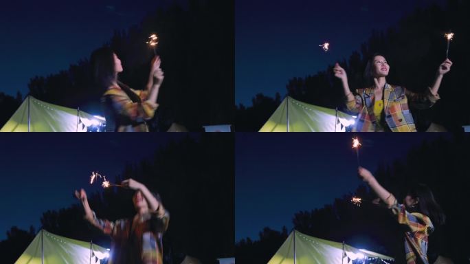 晚上一个年轻女孩在露营地放烟花