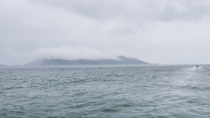 海面上下雨了拍远处的海岛被雾气笼罩