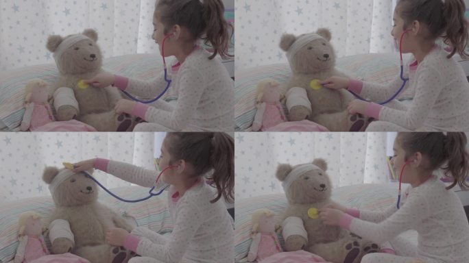 小女孩在床上和泰迪熊玩医生