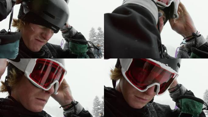 慢镜头拍摄的是一名20多岁的男性滑雪运动员戴上护目镜，准备在雪地上滑雪。冬日