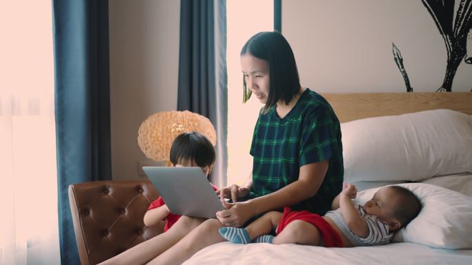 现代母亲与儿子一起使用笔记本电脑。