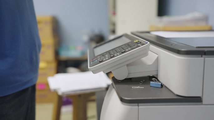 办公室工作人员使用复印机复印文件。