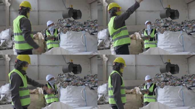 在新冠肺炎疫情中回收中心工作的工程师。维护工程师和领班在废物分离工厂共同工作时戴着防护面罩。
