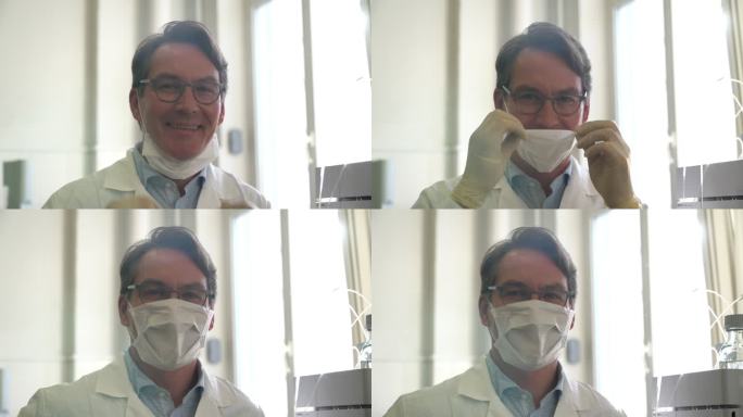 英俊的专业科学家面对镜头微笑，然后戴上防护口罩