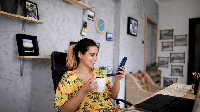 女商人在咖啡时间用智能手机上网