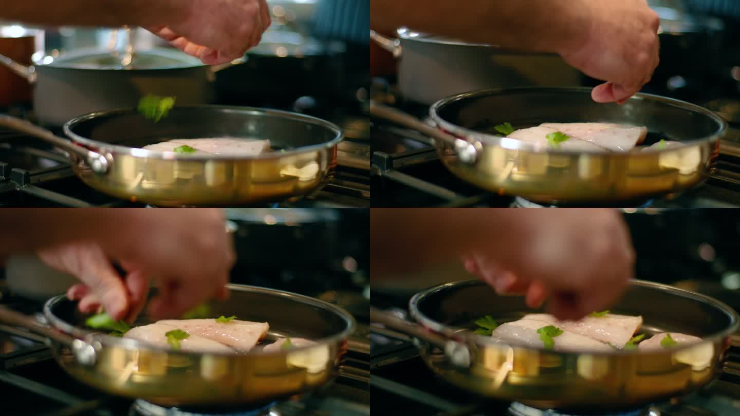 厨师在煎锅中的鱼片中加入香草
