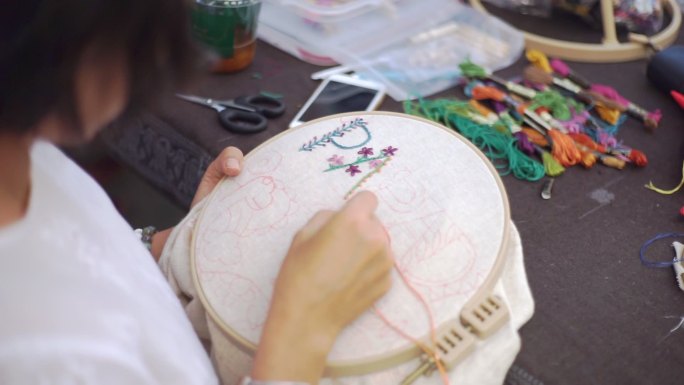 手女人在铁箍上绣花，手工制作和手工艺概念。