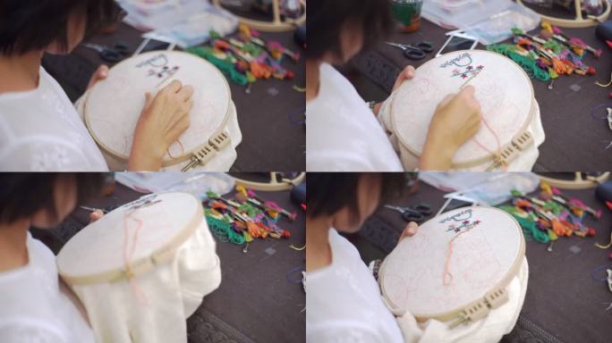 手女人在铁箍上绣花，手工制作和手工艺概念。