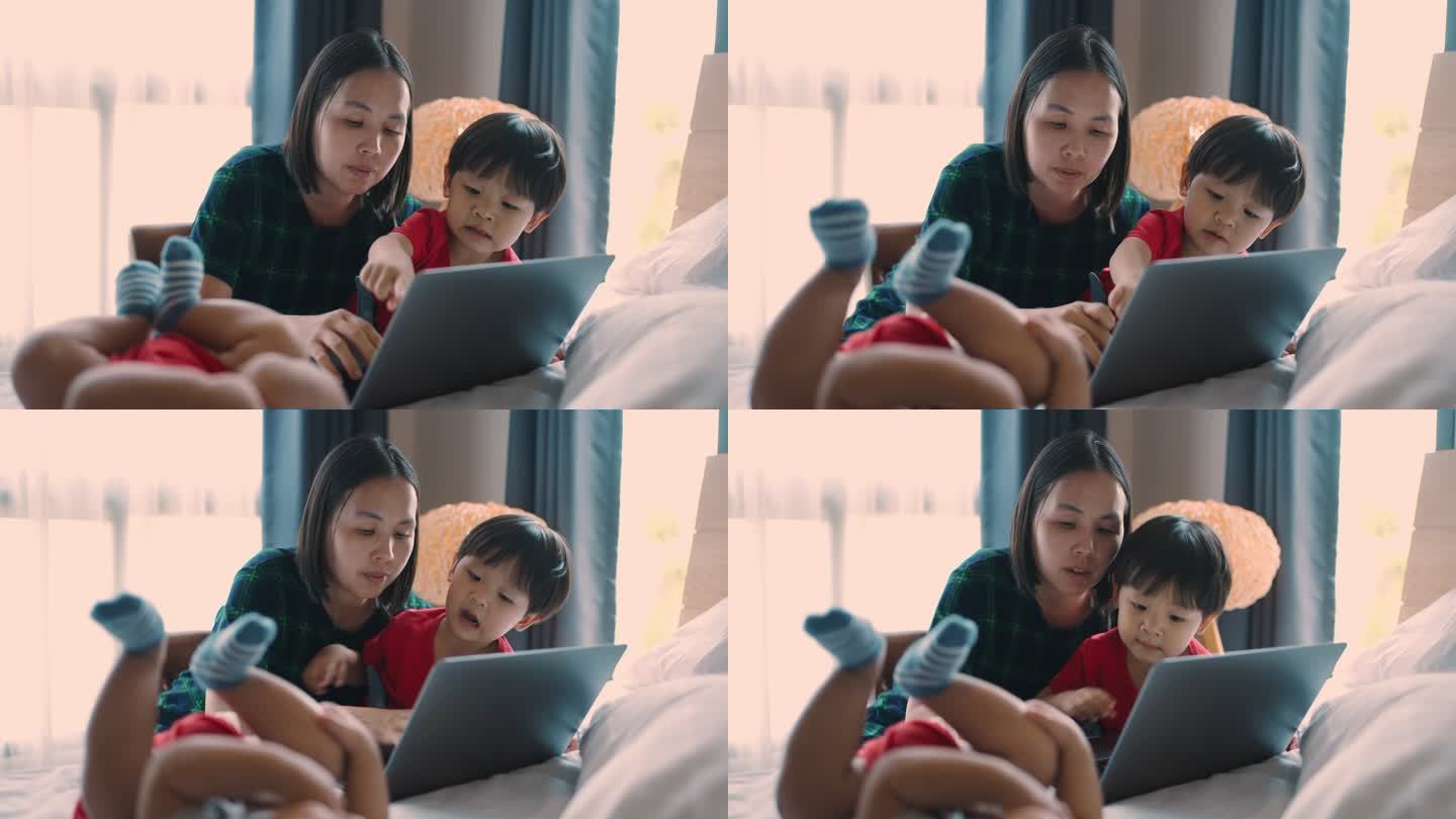 现代母亲与儿子一起使用笔记本电脑。