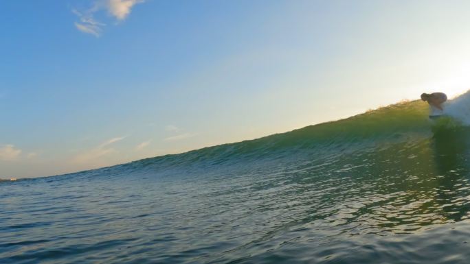 日落时分在哥斯达黎加海浪上冲浪的女子