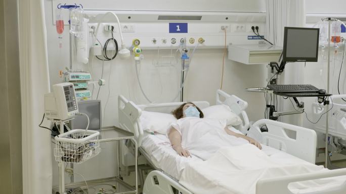 重症监护病房病床上戴口罩的女性患者