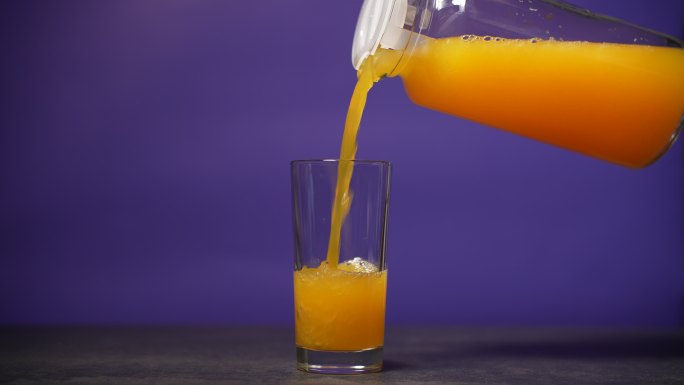 将橙汁倒入玻璃杯健康维生素绿色有机