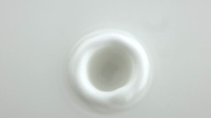 牛奶滴落入白色奶油液体中