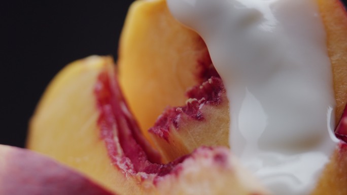 酸奶倒在新鲜的桃子片上。极度特写