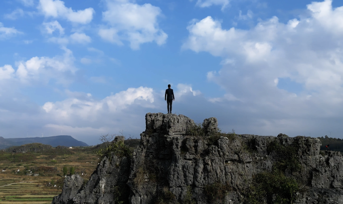 西装男士站在山顶眺望远方勇登高峰胸有成竹