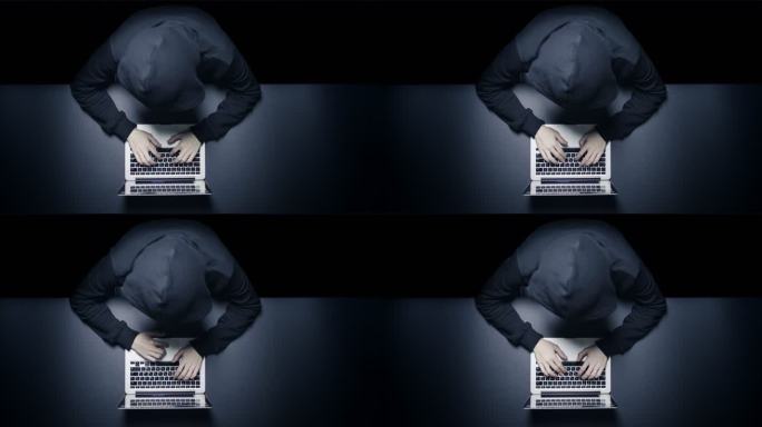 匿名黑客在黑暗中使用笔记本电脑
