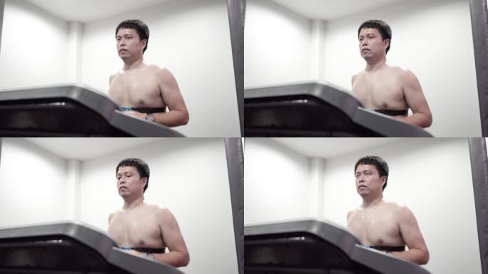 一名亚洲男子在家中跑步机上跑步时佩戴心率带。