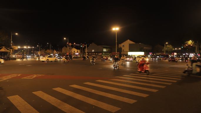 小镇夜晚十字路口延时拍摄汽车行人过马路