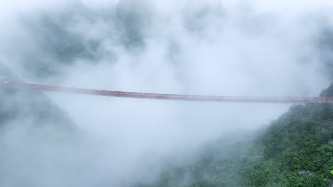 雨后云雾里桂林喀斯特山峰间横跨的铁索桥