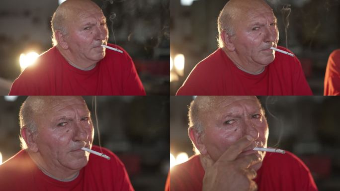 严肃的老年人抽烟，看着镜头