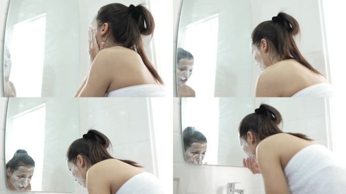 年轻女子在家里的浴室里洗脸