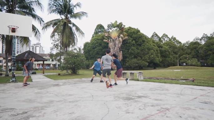 慢动作Z世代亚洲中国青少年男孩在周末早晨与朋友练习篮球比赛时阻挡挑战球员投篮