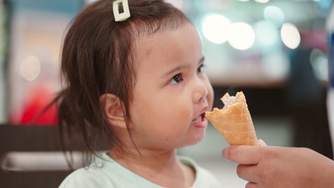 亚洲小女孩在室内餐厅吃冰淇淋