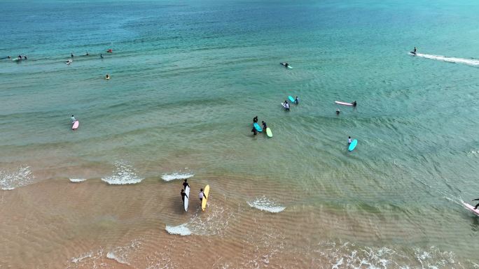 海南三亚大东海沙滩海边冲浪玩水的人群航拍