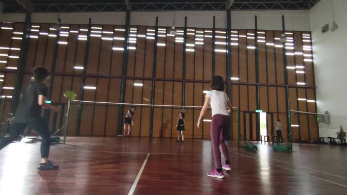 亚洲中国双人羽毛球运动员在羽毛球场上比赛
