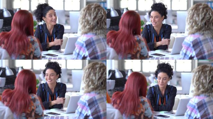 4k视频在一间色彩斑斓的现代办公室里，微笑迷人的黑发、金发和红发女子之间的商务会议