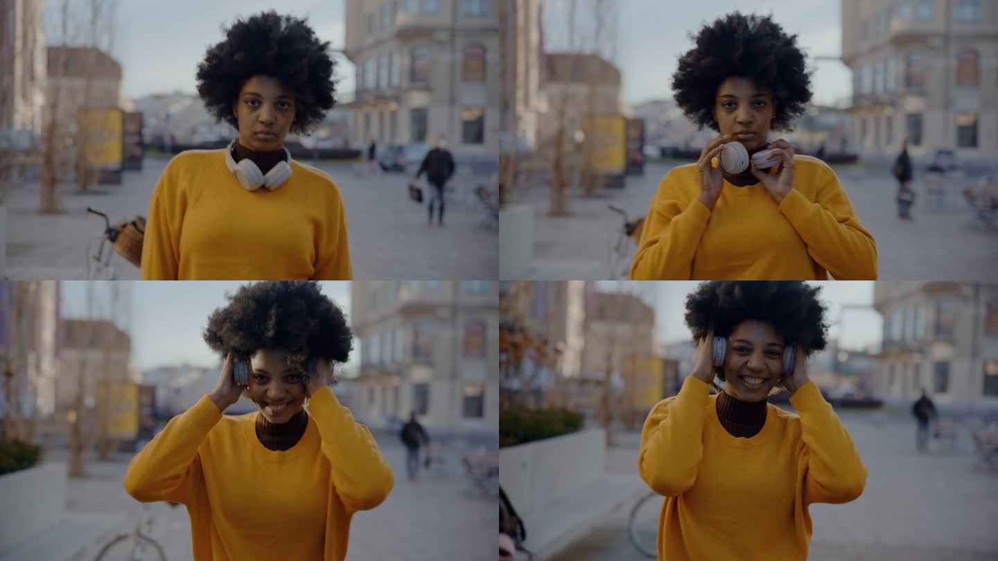年轻的黑人妇女戴上耳机，开始在城市里跳舞