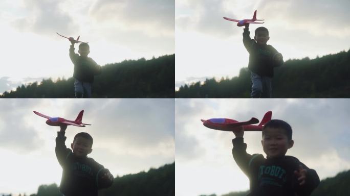 小孩拿着飞机模型草地逆光奔跑孩子微笑脸庞