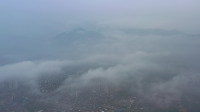 航拍雾天云端之上俯瞰城市建筑高楼