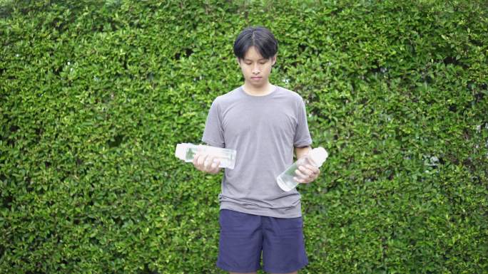 亚洲男子在家门口用水瓶锻炼身体