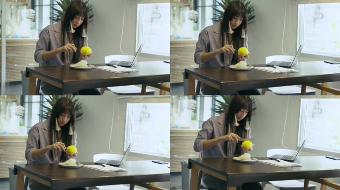 亚洲女子在桌上剥芒果