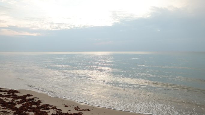 2022年6月25日，在和平的海滩日出期间，佛罗里达岛棕榈滩，碧绿海浪轻柔地扫过海岸线，海岸线闪闪发