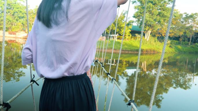 亚洲女孩早上走在湖上的长袍桥上，生活方式理念。